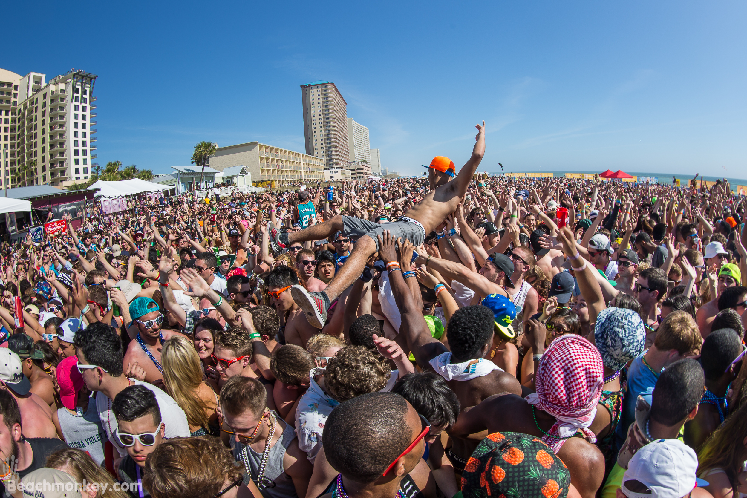 man crowdsurfing at a beach party