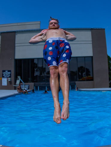Guy doing incredible floating jump into pool, photo by summer party photographer Beachmonkey