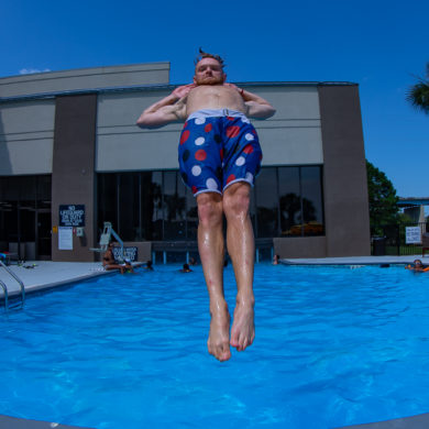 Guy doing incredible floating jump into pool, photo by summer party photographer Beachmonkey