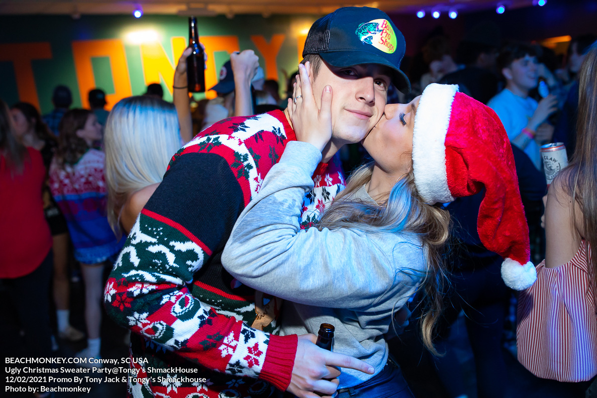 kiss on cheek Myrtle Beach Photographer at Tongy's Shmackhouse for the Ugly Christmas Sweater Party Dec 2nd, 2021 in Conway, SC USA  by Myrtle Beach photographer Beachmonkey