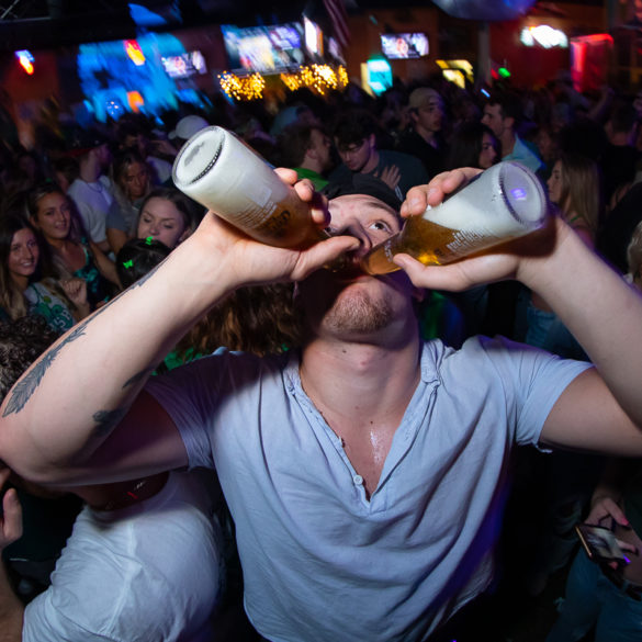 guy chugging two beers at Tongy's Shmackhouse for St Patrick's Day Thurday March 17 2022 in Conway, SC USA photos ﻿Separator ﻿ by Myrtle Beach photographer Beachmonkey