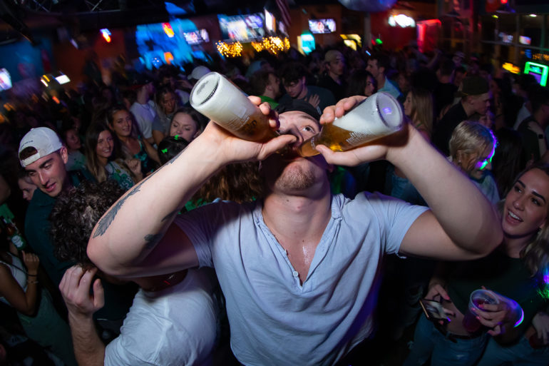 guy chugging two beers at Tongy's Shmackhouse for St Patrick's Day Thurday March 17 2022 in Conway, SC USA photos ﻿Separator ﻿ by Myrtle Beach photographer Beachmonkey