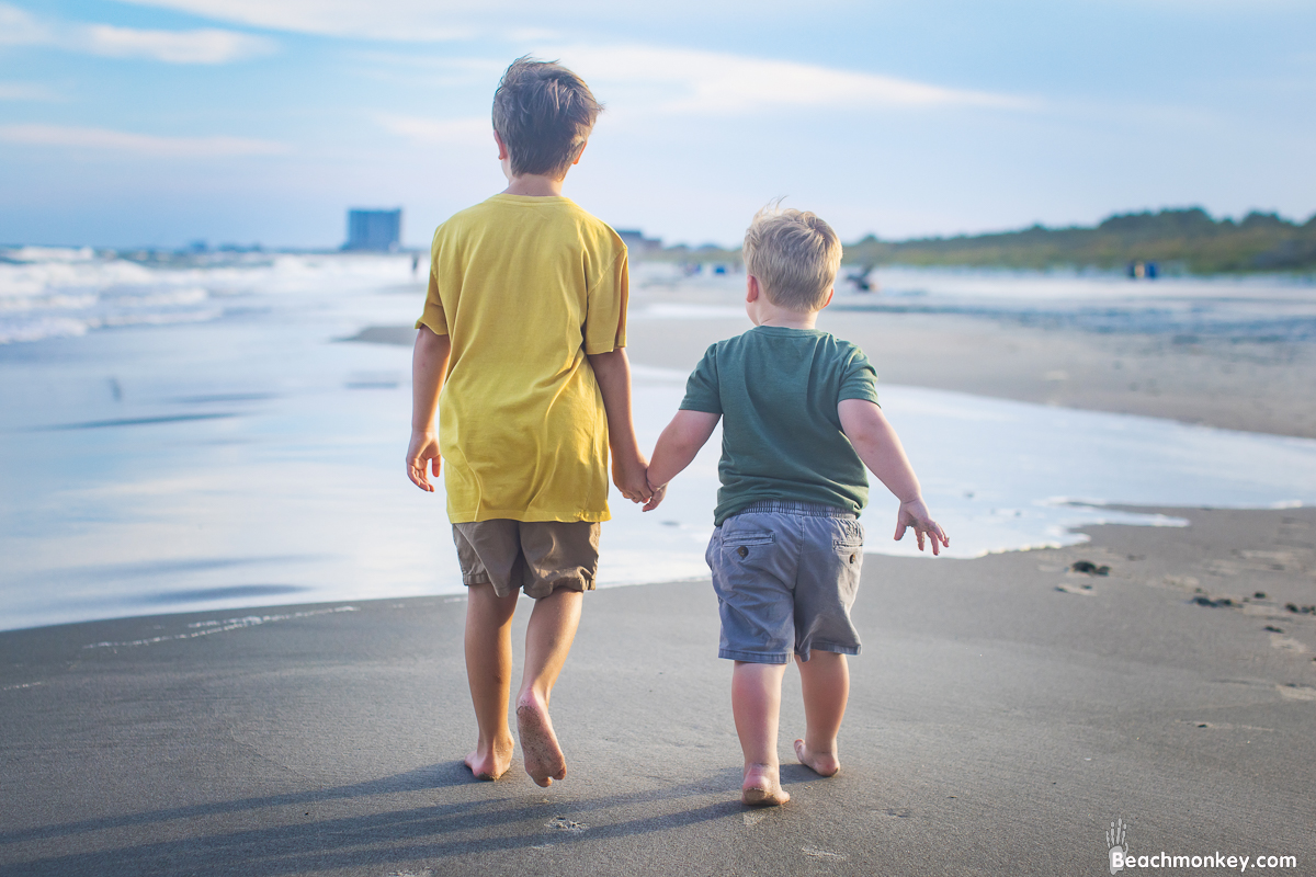 family photo shoot in Myrtle Beach in July 2022 with children holding hands and walking