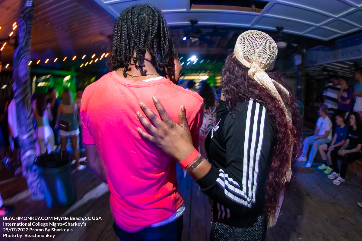 woman touching man's back at sharkeys bar in Myrtle Beach, SC on international college night in July 25 2022