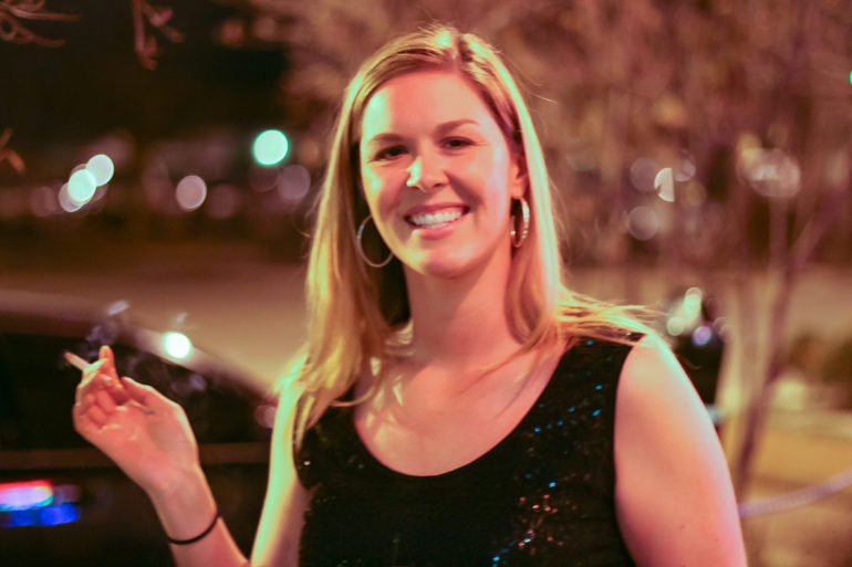 girl smoking outside pink door in louisville