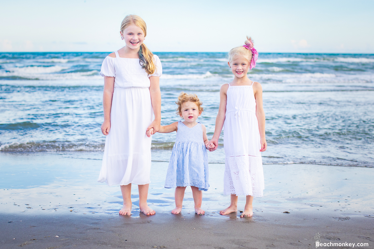 three girls holding hands A family Beach photo shoot in North Myrtle Beach, SC with Ashlie's family by Beachmonkey of beachmonkey photography, a family photographer on August 4th 2022
