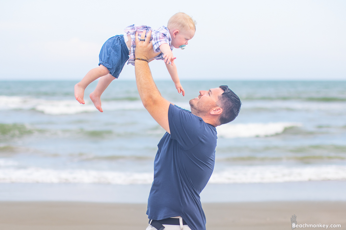 dad lifting baby A family Beach photo shoot in North Myrtle Beach, SC with Bob's family by Beachmonkey of beachmonkey photography, a family photographer August 2022