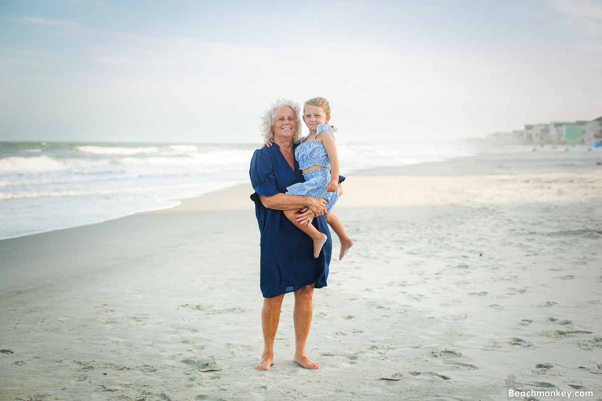Child with grandmother at A family photo shoot in Garden City, SC at the Garden City Pier with Deanna's family by Slava of beachmonkey photography, a family photographer July 2022