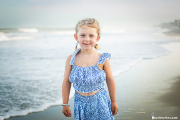 Portrait of a child on the beach A family photo shoot in Garden City, SC at the Garden City Pier with Deanna's family by Slava of beachmonkey photography, a family photographer July 2022