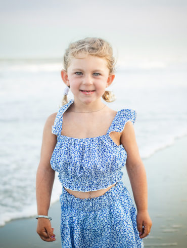 Portrait of a child on the beach A family photo shoot in Garden City, SC at the Garden City Pier with Deanna's family by Slava of beachmonkey photography, a family photographer July 2022