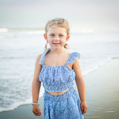 Portrait of a child on the beach A family photo shoot in Garden City, SC at the Garden City Pier with Deanna's family by Slava of beachmonkey photography, a family photographer July 2022