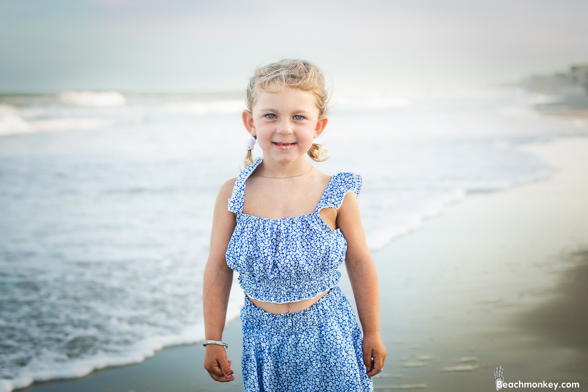 portrait of a child on the beach A family photo shoot in Garden City, SC at the Garden City Pier with Deanna's family by Slava of beachmonkey photography, a family photographer july 2022