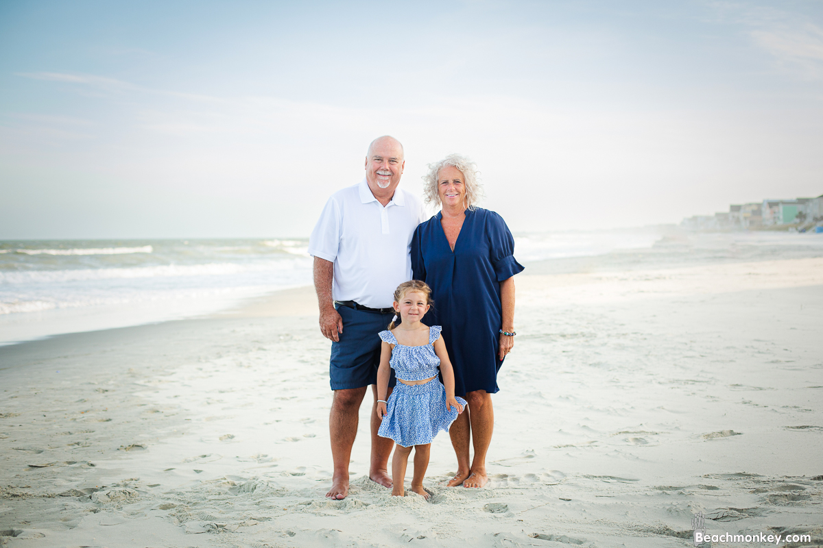 Grand parents with grand daughter on the beach A family photo shoot in Garden City, SC at the Garden City Pier with Deanna's family by Slava of beachmonkey photography, a family photographer July 2022