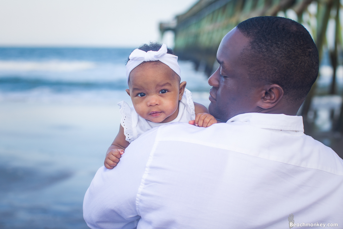 baby and dad A family Beach photo shoot in Myrtle Beach, SC with Jasmine's family by Beachmonkey of beachmonkey photography, a family photographer on July 21st 2022