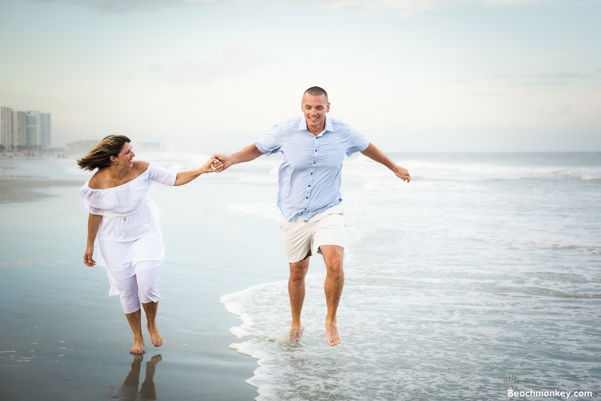 happy couple in surf at A family Beach photo shoot in Myrtle Beach, SC USA with Kerry's family by Slava of beachmonkey photography, a family photographer on July 18th 2022