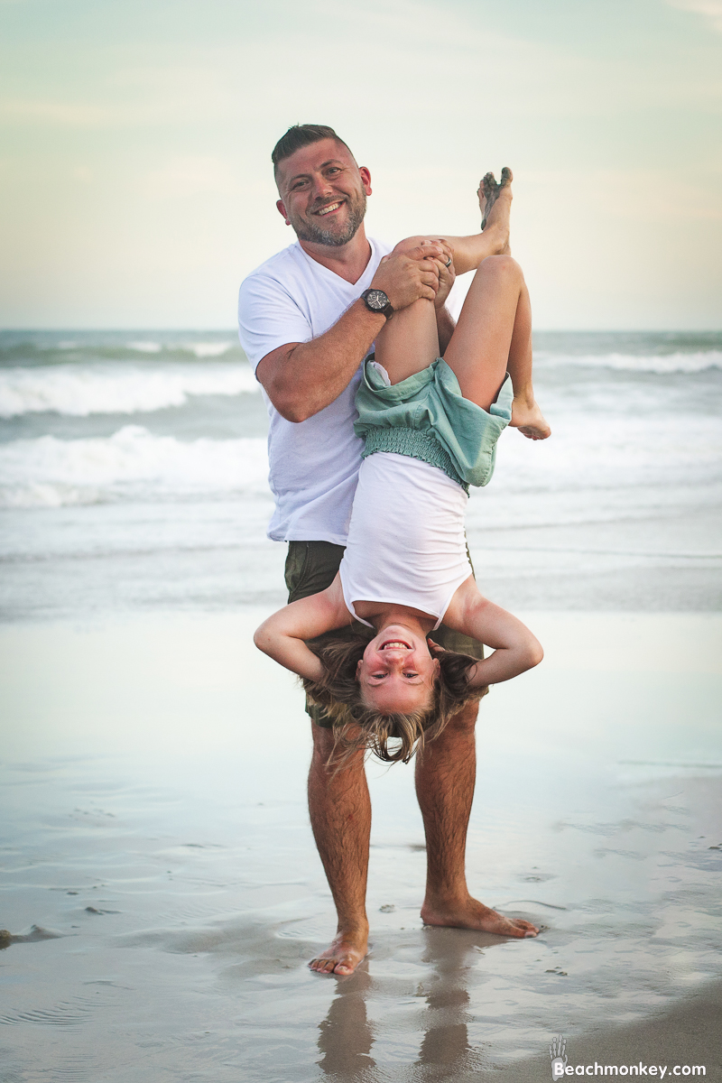 up side down daughter and father at a A family photo shoot in Myrtle Beach, SC at Myrtle Beach State Park with Larry's family by Slava of beachmonkey photography, a family photographer July 2022