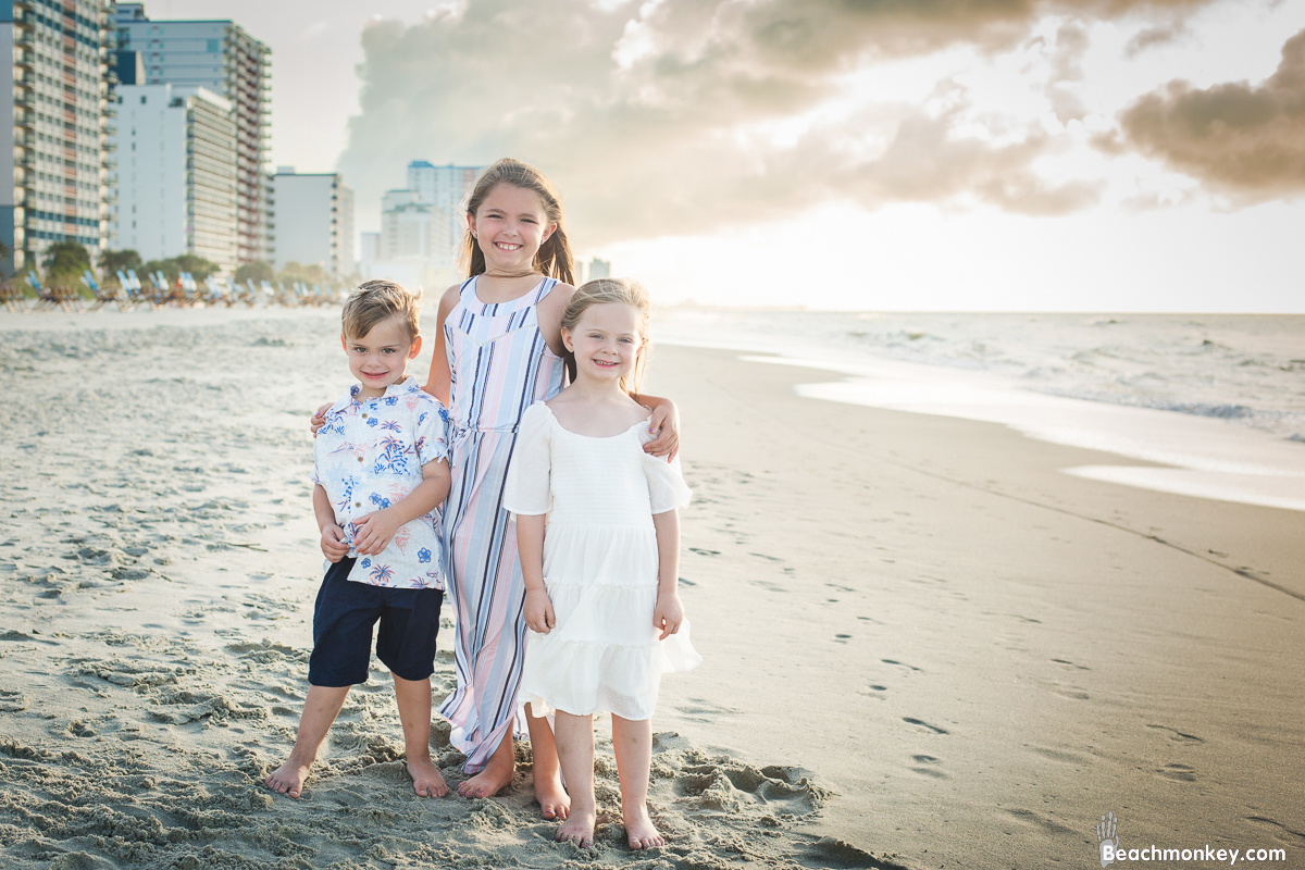 three children on the beach at A family Beach photo shoot in Myrtle Beach, SC USA with Rhonda's family by Slava of beachmonkey photography, a family photographer on July 25th 2022
