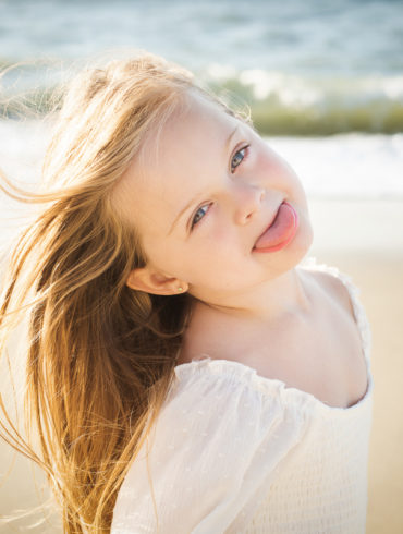 child sticking out tonge at A family Beach photo shoot in Myrtle Beach, SC USA with Rhonda's family by Slava of beachmonkey photography, a family photographer on July 25th 2022
