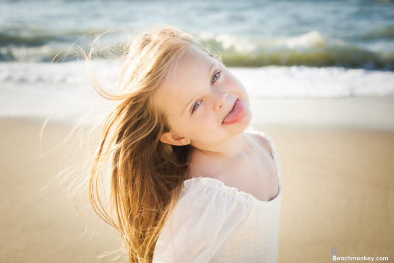 child sticking out tonge at A family Beach photo shoot in Myrtle Beach, SC USA with Rhonda's family by Slava of beachmonkey photography, a family photographer on July 25th 2022