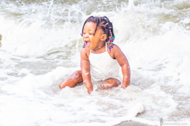 baby playing in water in myrtle Beach, SC for a family photo shoot by Beachmonkey photography