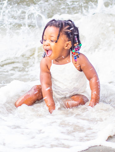 baby playing in water in myrtle Beach, SC for a family photo shoot by Beachmonkey photography