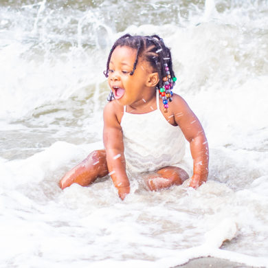 baby playing in water in myrtle Beach, SC for a family photo shoot by Beachmonkey photography