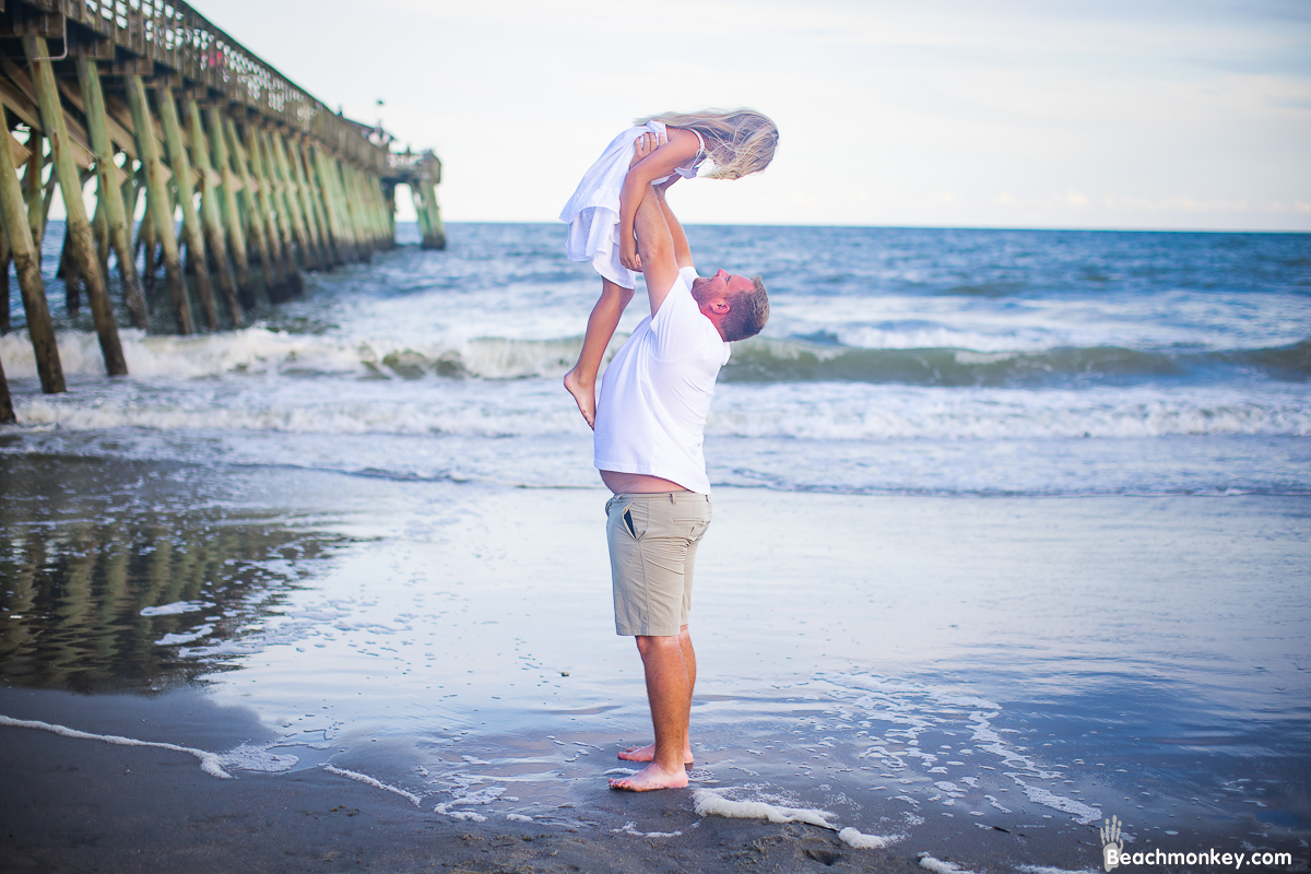 father lifting daughter A family Beach photo shoot in Myrtle Beach, SC with Cassies's family by Beachmonkey of beachmonkey photography, a family photographer on July 16th 2022