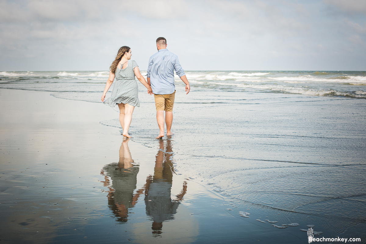 romantic couple walking A family Beach photo shoot in North Myrtle Beach, SC with Ashley's family by Slava of beachmonkey photography, a family photographer on July 7th 2022