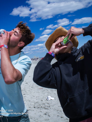 two guys shot gunning beer Delta Sigma Pi Virginia Tech Fraternity Beach Weekend in North Myrtle Beach, SC USA sponsored by Myrtlebeachtours.com April 9th 2022 Photos by Napoleon