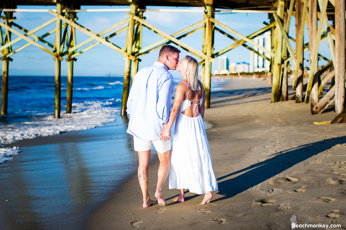 couple kissing A family Beach photo shoot in Myrtle Beach, SC USA with Dot's family by Beachmonkey of beachmonkey photography, a family photographer on August 9th 2022