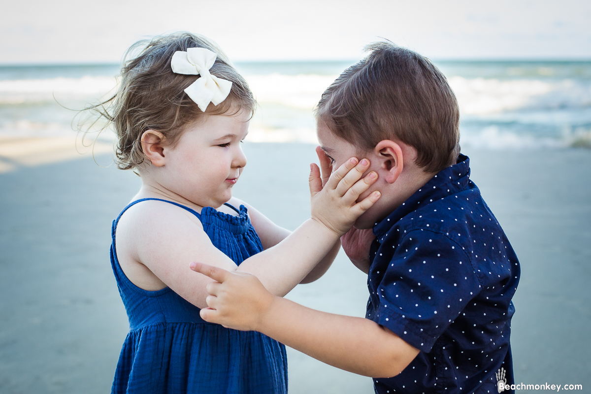 tender touch of two children A family Beach photo shoot in North Myrtle Beach, SC with Erin's family by Slava of beachmonkey photography, a family photographer on August 8th 2022