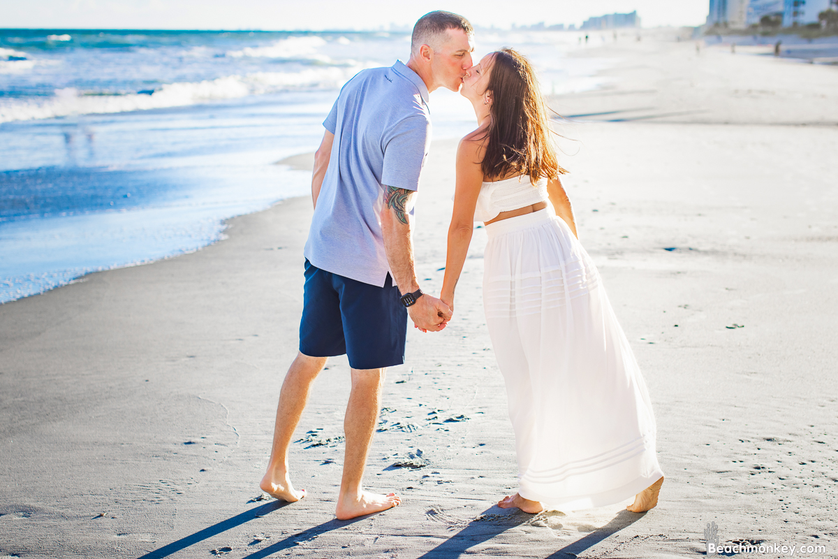couple kissing A family Beach photo shoot in North Myrtle Beach, SC with Amanda's family by Beachmonkey of beachmonkey photography, a family photographer on August 8th 2022