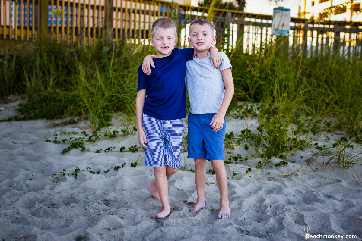 two brothers couple kissing A family Beach photo shoot in North Myrtle Beach, SC with Amanda's family by Beachmonkey of beachmonkey photography, a family photographer on August 8th 2022