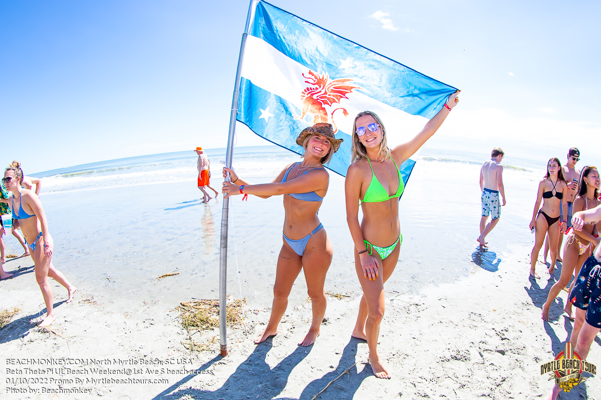 two pretty sorority girls in bikinis holding flag Beta Theta Pi U of Louisville Fraternity Beach Weekend North Myrtle Beach, SC USA sponsored by Myrtlebeachtours.com October 1st 2022 Photos by Beachmonkey a Myrtle Beach photographer